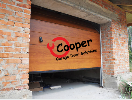 Wood-finish sectional garage door in a brick opening